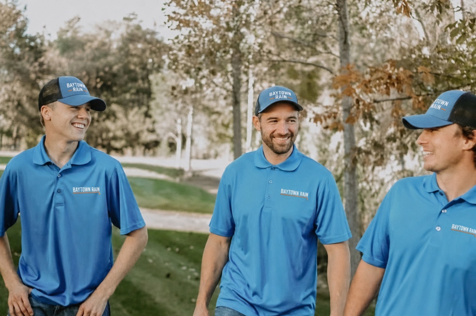 Baytown Rain branding on blue polo shirts and caps