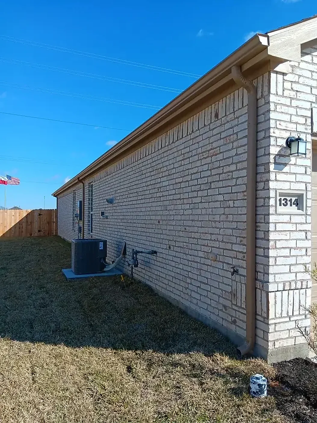 Light siding home with a straight seamless gutter run