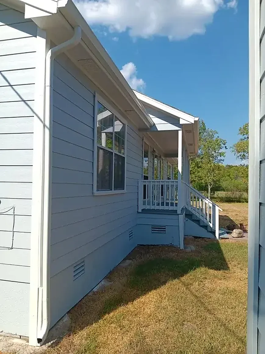 White gutter run along a light siding exterior