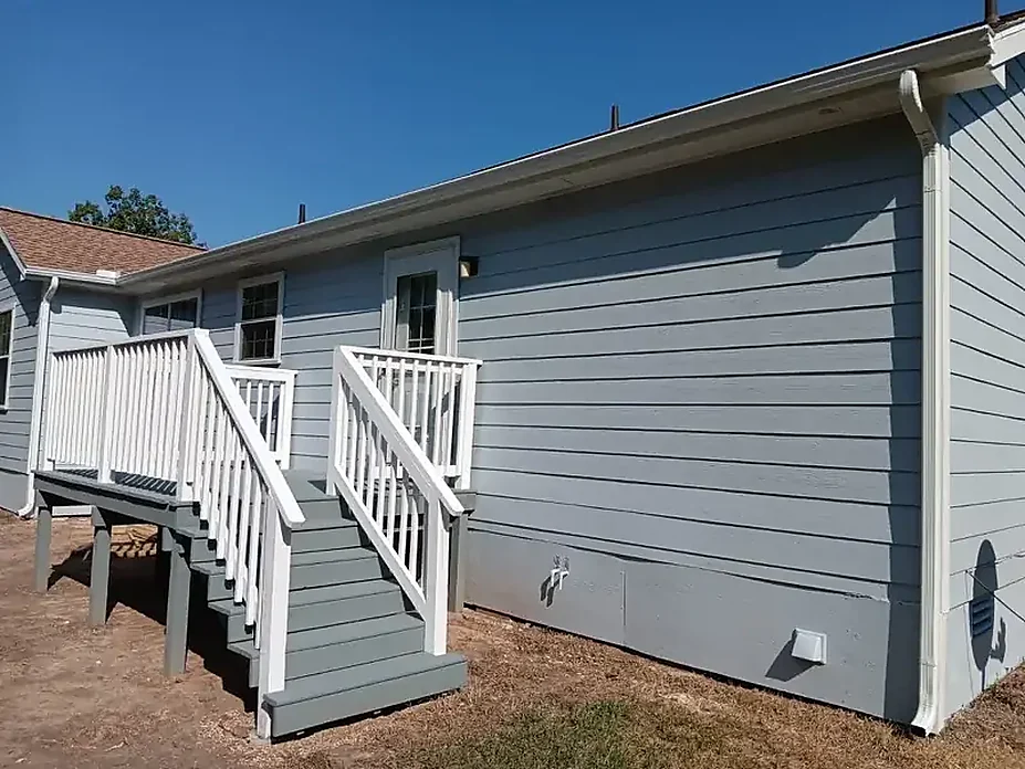 Rear exterior staircase beneath a continuous gutter line