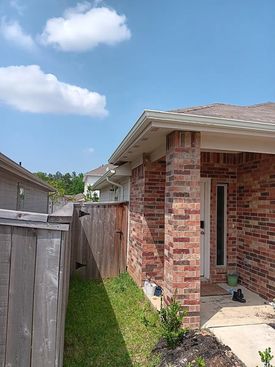 Brick side yard with gutter run and fence-line drainage