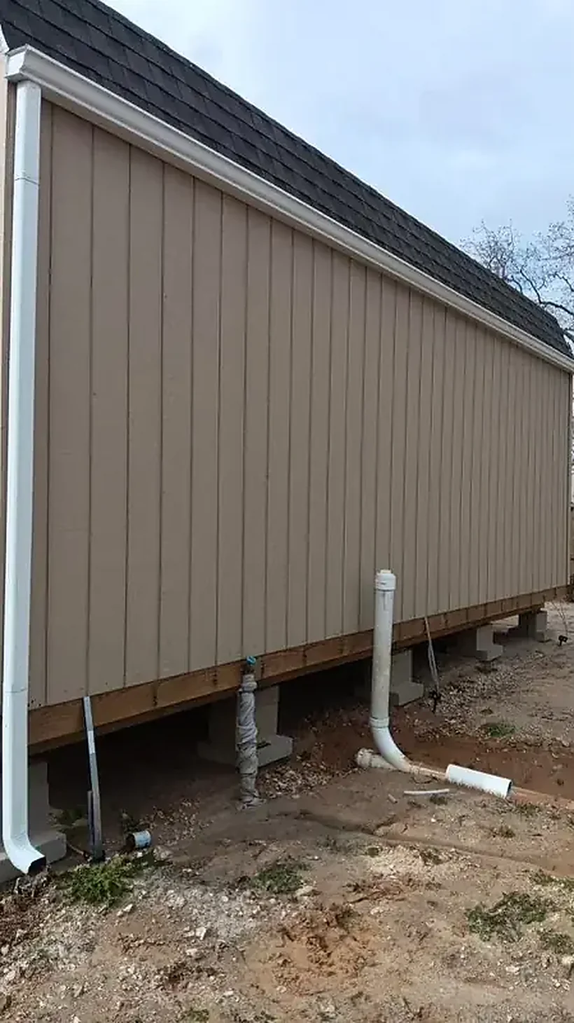 Outbuilding wall with downspout extensions