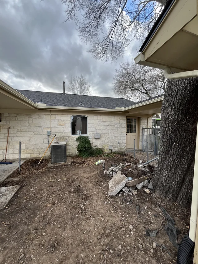 Gutter and downspout routing around a covered outdoor living area