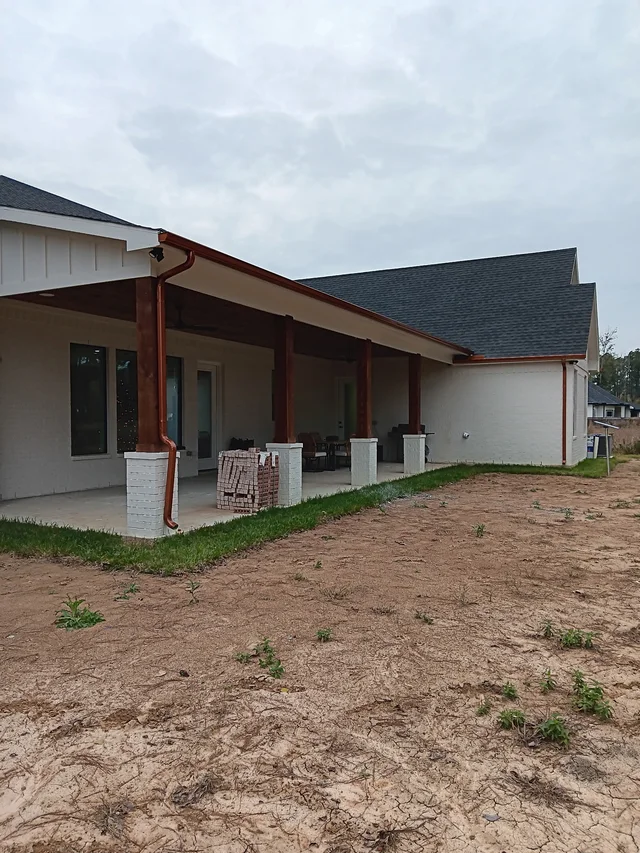 Dark gutters and downspouts around a brick exterior
