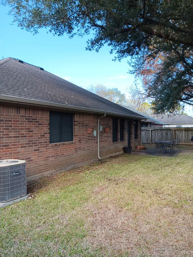 Gutters tracing the roof edge beside an enclosed yard