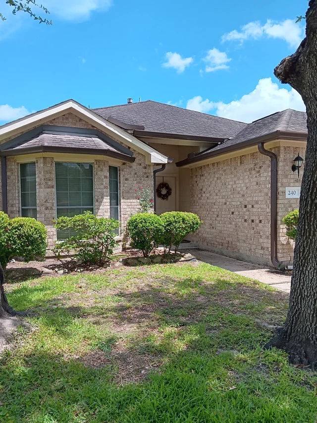 Dark gutters and downspouts around a brick exterior