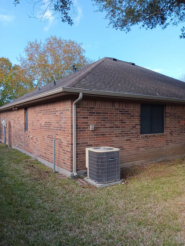 Gutters tracing the roof edge beside an enclosed yard