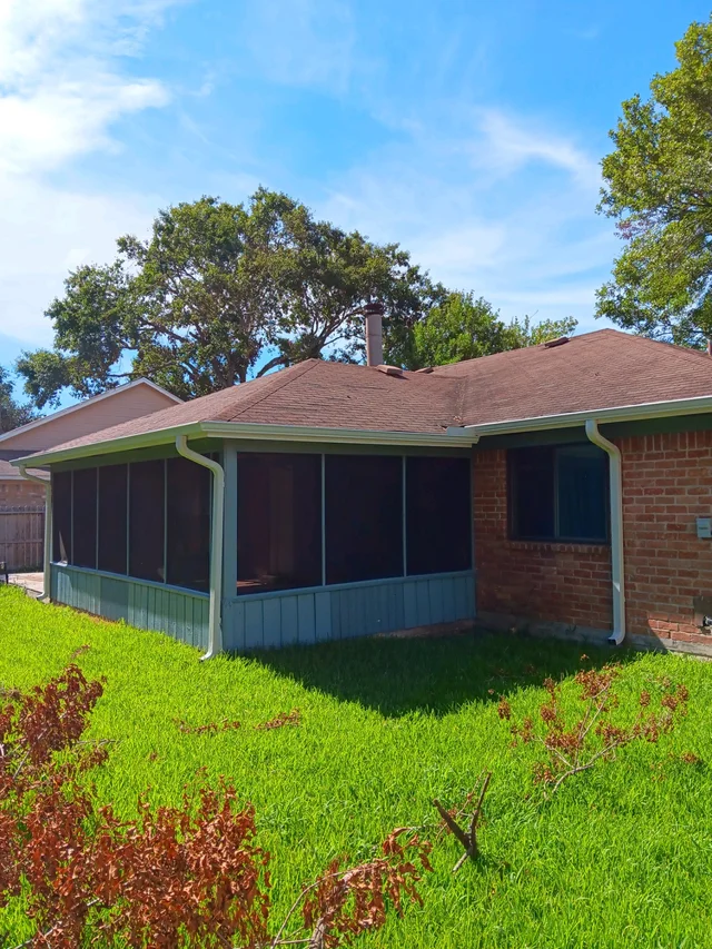 Dark gutter routing along a wood-sided home