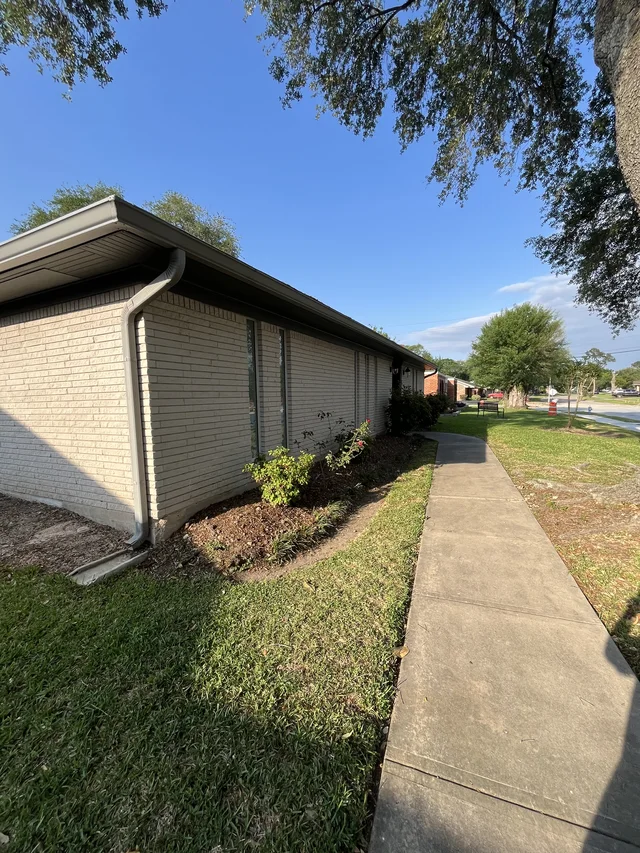 Gutters tracing the roof edge beside an enclosed yard