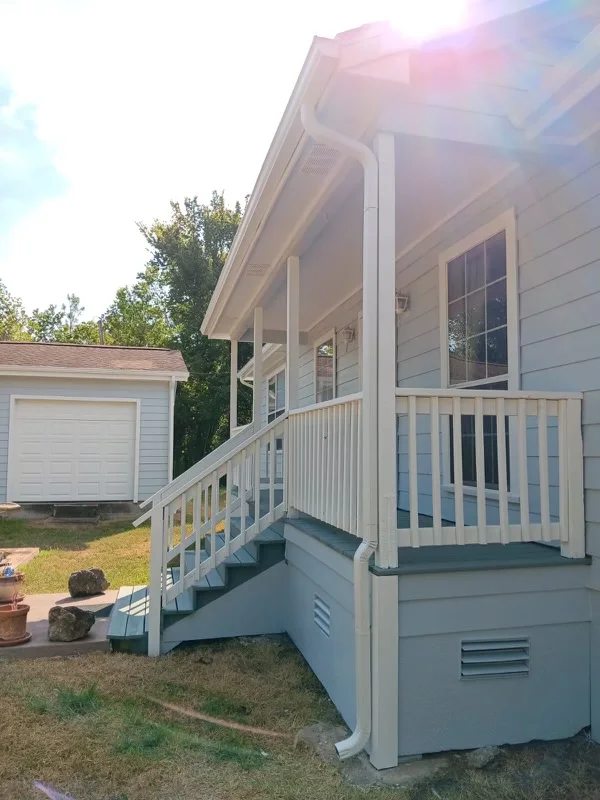 White gutters and downspouts against blue-gray siding