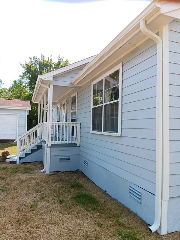 White gutters and downspouts against blue-gray siding