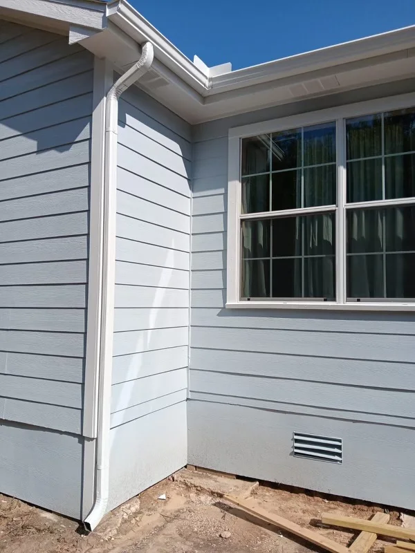 White gutters and downspouts against blue-gray siding