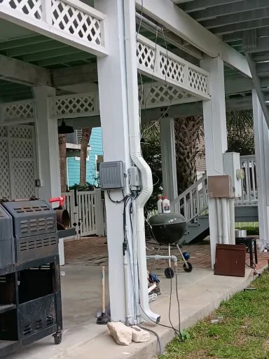 White downspout routing beside a raised coastal-style home