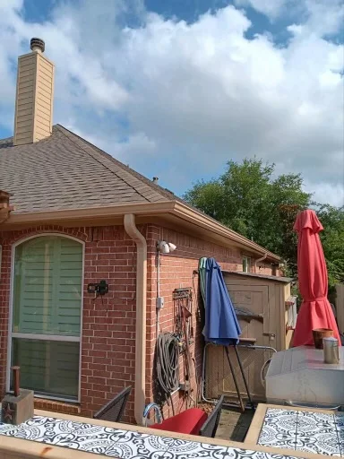Gutter and downspout routing around a covered outdoor living area