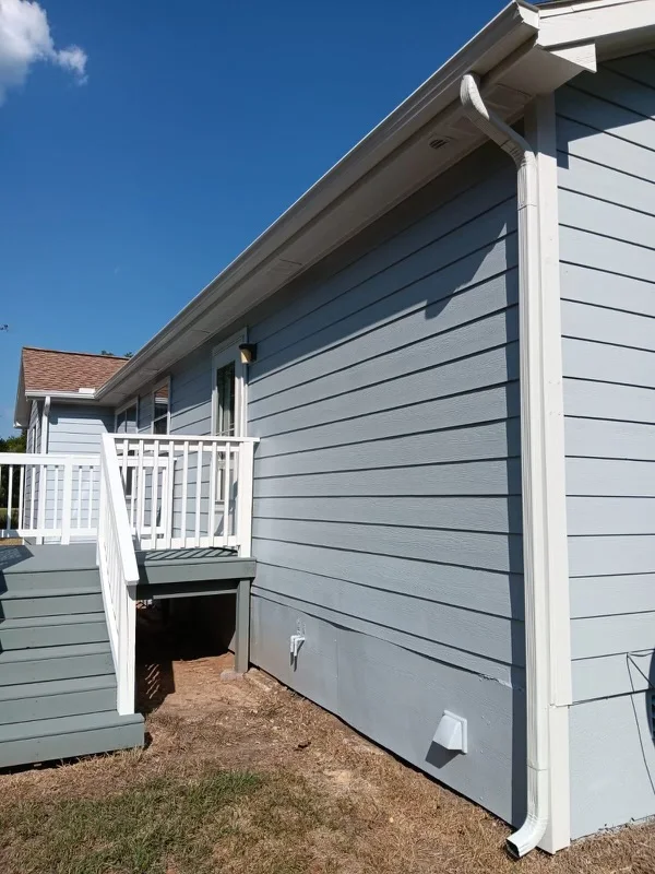 White gutters and downspouts against blue-gray siding