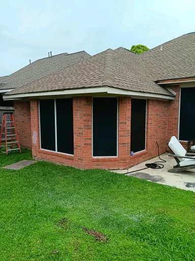 Pale gutter and downspout at the corner of a brick home