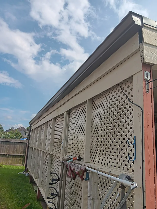 Dark gutters and downspouts around a brick exterior