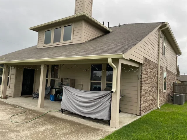 Gutter and downspout routing around a covered outdoor living area