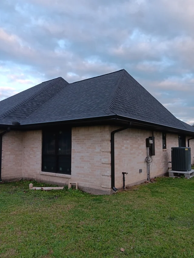 Dark gutters and downspouts around a brick exterior