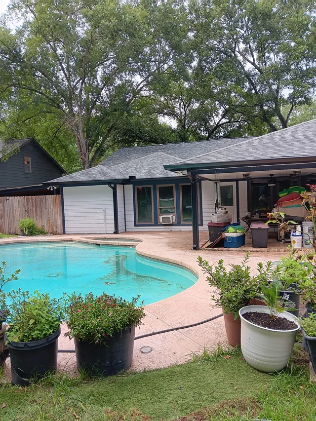 Gutter and downspout routing around a covered outdoor living area
