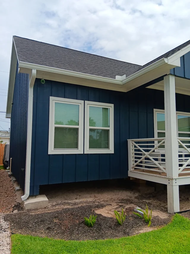 White gutters and downspouts against blue-gray siding