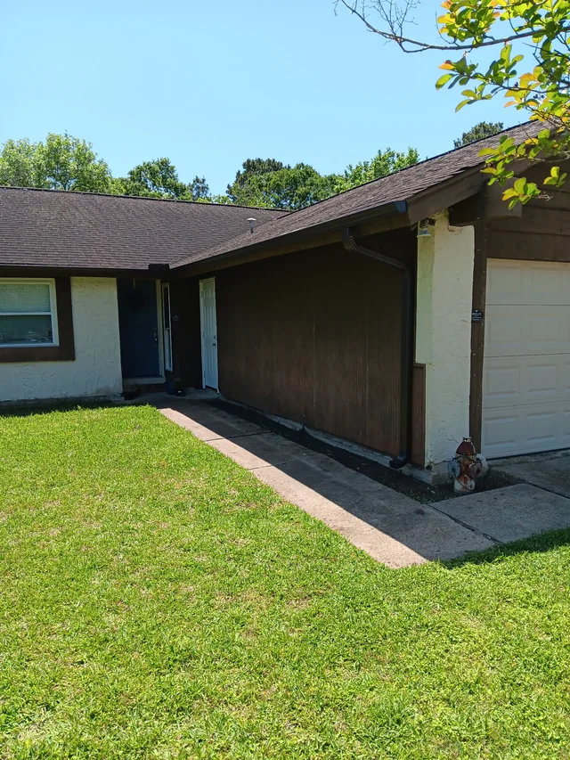 Gutter and downspout routing around a covered outdoor living area