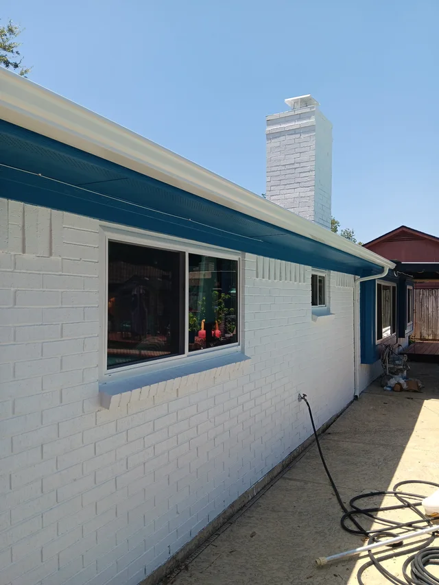 Gutters tracing the roof edge beside an enclosed yard