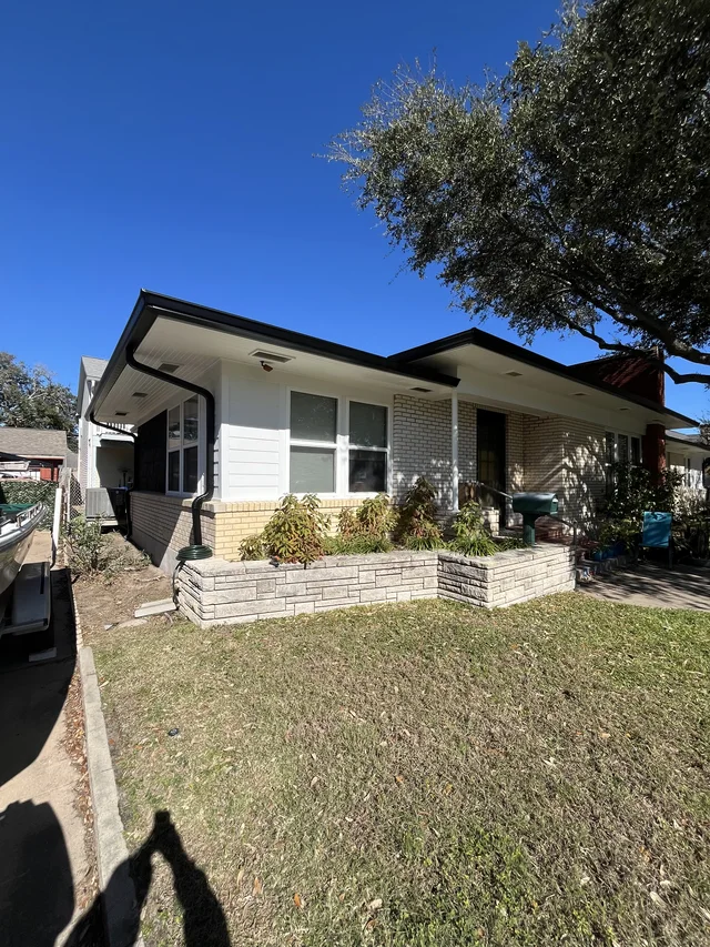Dark roofline trim above a single-story brick home