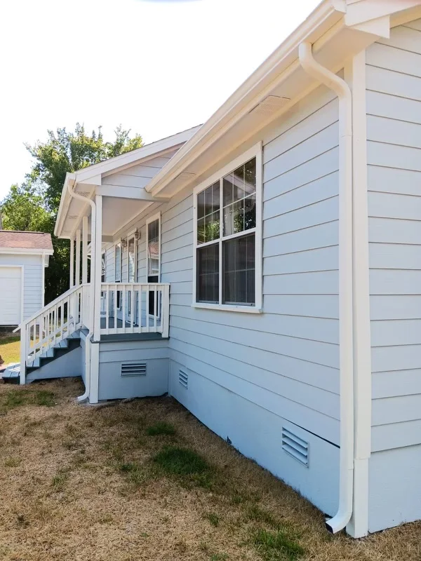 White gutters and downspouts against blue-gray siding