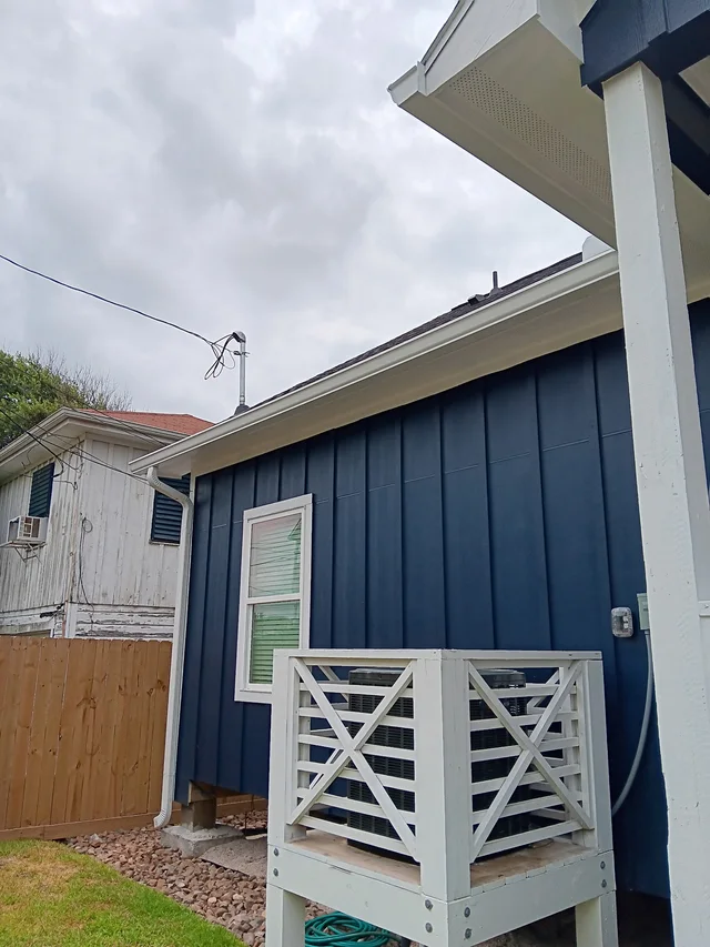 White gutters and downspouts against blue-gray siding