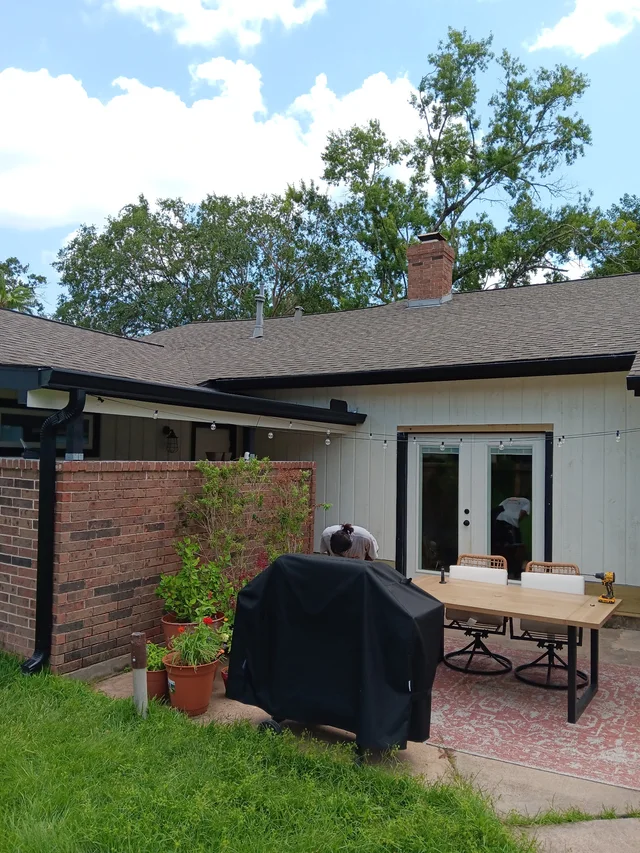 Gutter and downspout routing around a covered outdoor living area