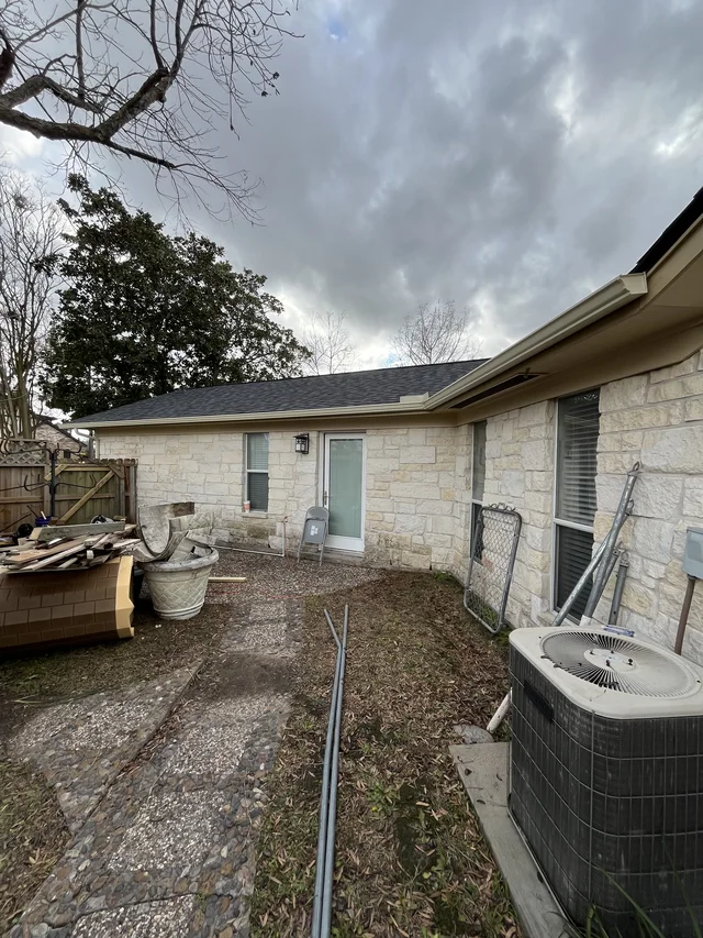 Gutter and downspout routing around a covered outdoor living area