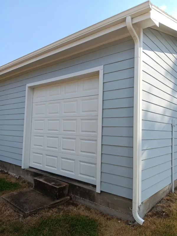 White gutters and downspouts against blue-gray siding