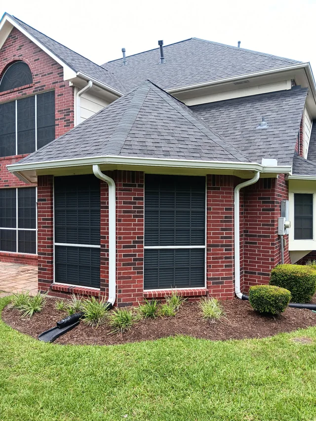 Close view of a white gutter where two roof levels meet