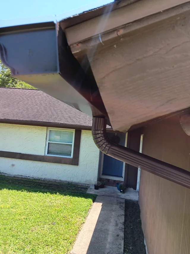 Gutter and downspout routing around a covered outdoor living area