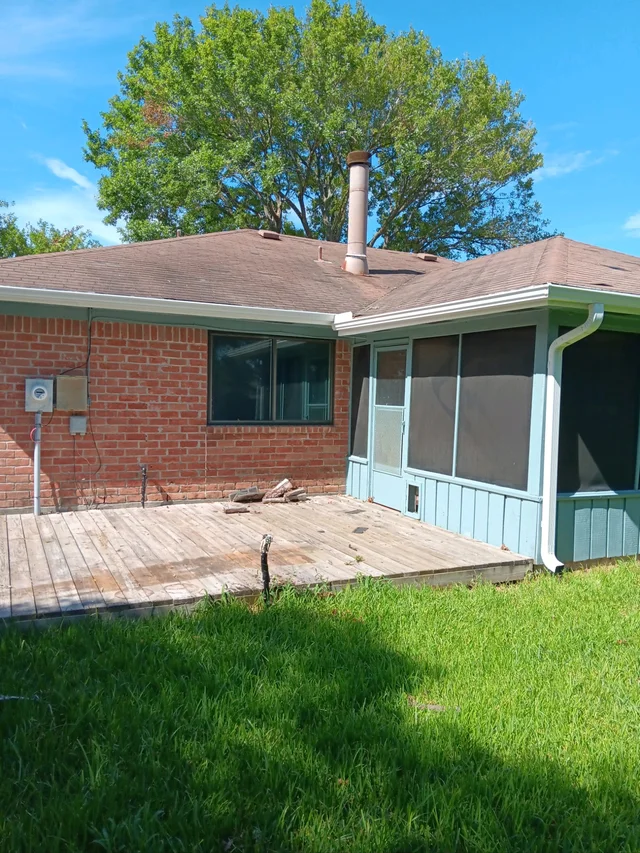 Dark gutter routing along a wood-sided home