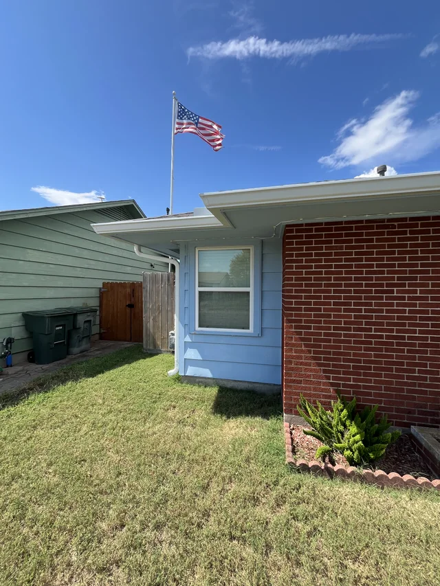 Dark gutters and downspouts around a brick exterior