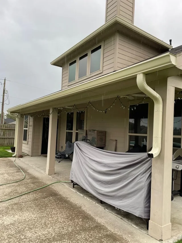 Gutter and downspout routing around a covered outdoor living area