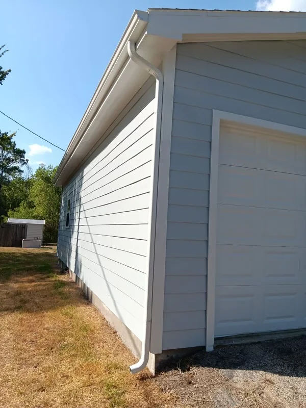 White gutters and downspouts against blue-gray siding