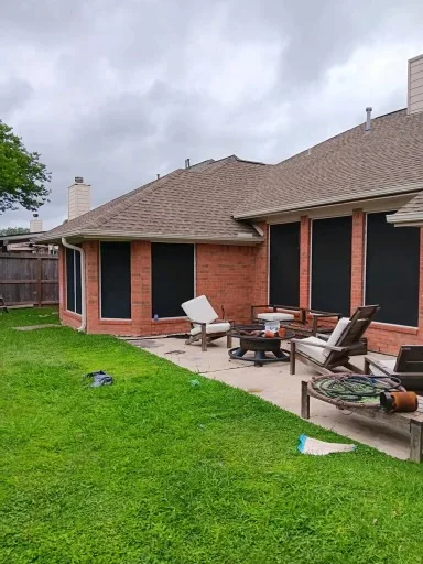 Pale gutter and downspout at the corner of a brick home