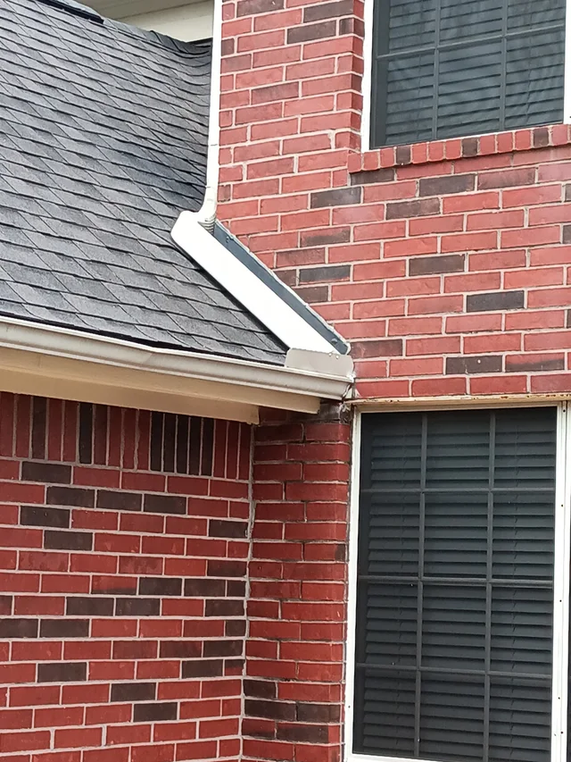 Close view of a white gutter where two roof levels meet