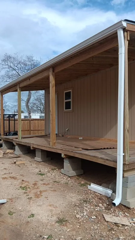 Gutter and downspout routing around a covered outdoor living area