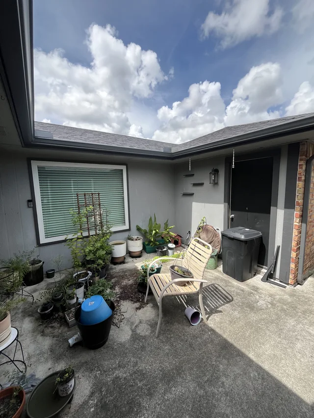 Gutter and downspout routing around a covered outdoor living area