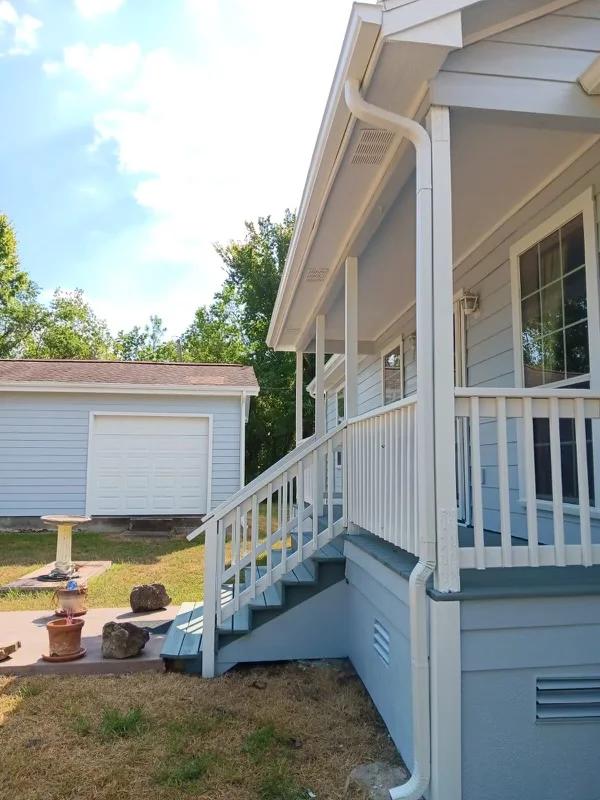 White gutters and downspouts against blue-gray siding
