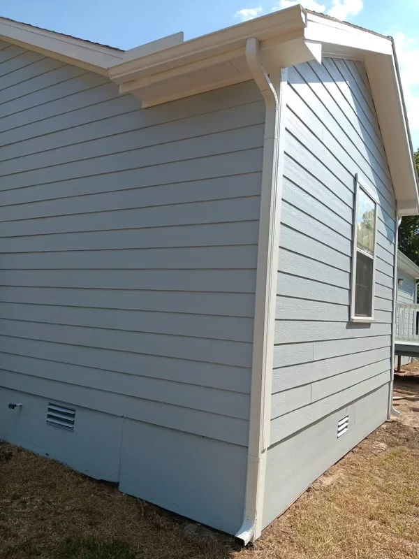 White gutters and downspouts against blue-gray siding
