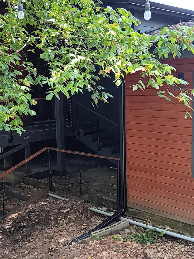 Dark gutter routing along a wood-sided home
