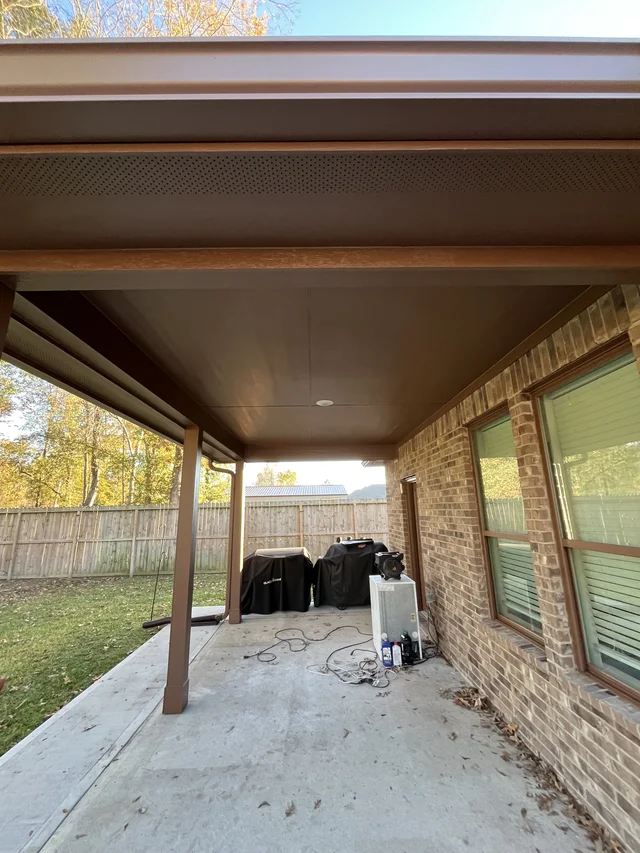 Gutter and downspout routing around a covered outdoor living area