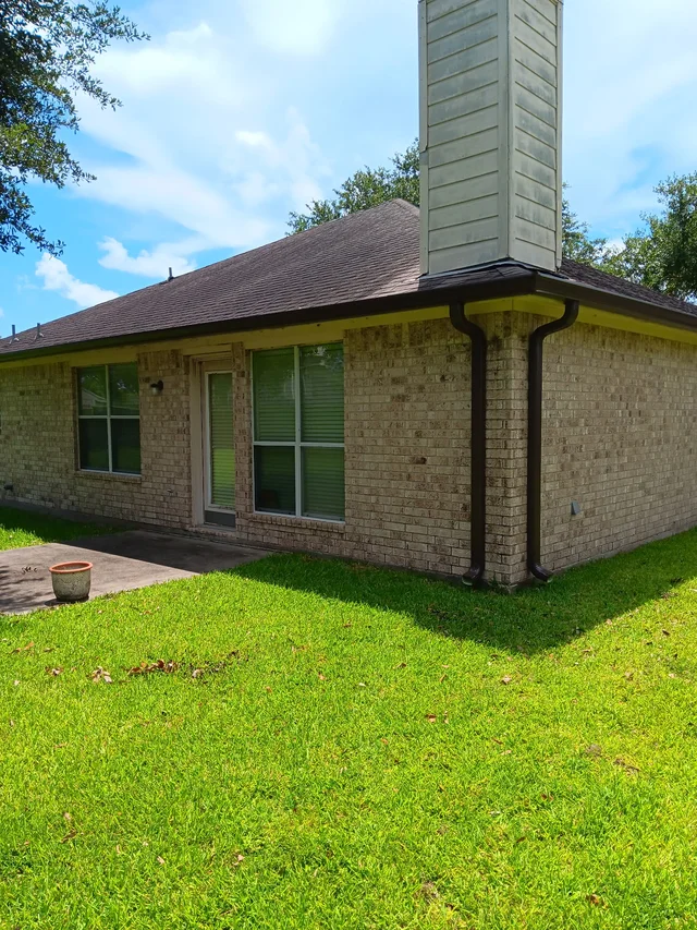 Dark gutters and downspouts around a brick exterior