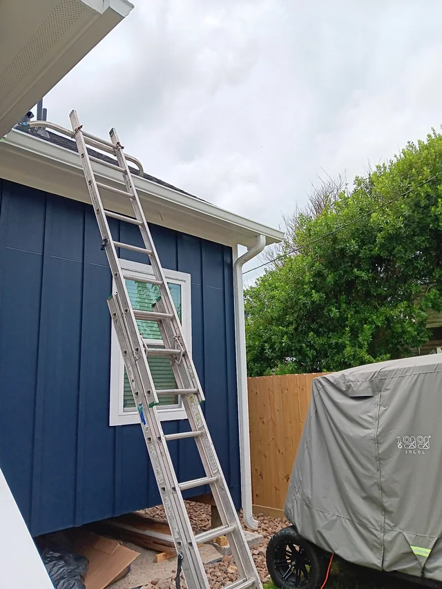 White gutters and downspouts against blue-gray siding