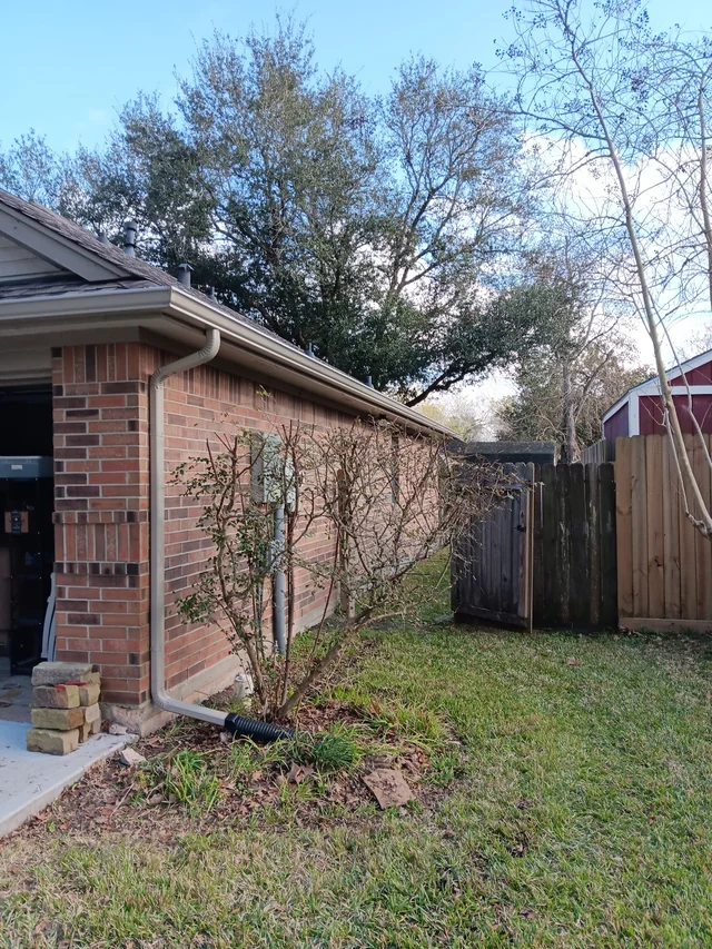 Gutters tracing the roof edge beside an enclosed yard